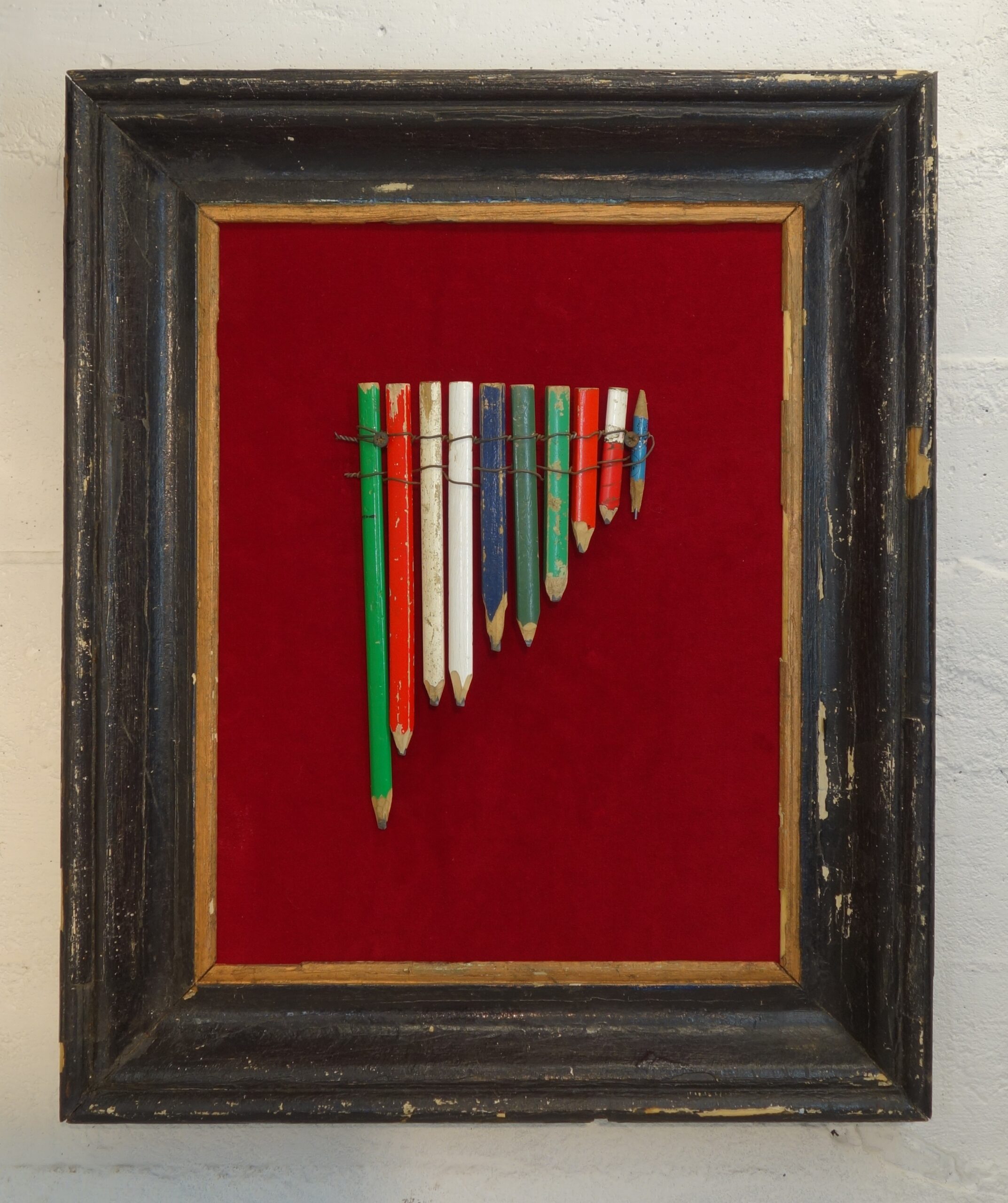 Asamblaż Wojciecha Roskosza „Fletnia Pana – kleptomana” z ołówków zebranych na budowie, w ramie na pluszu – obiekt sztuki współczesnej o pamięci pracy i materii.